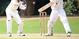 Batsman playing cricket shot with Wicket Keeper behind stumps